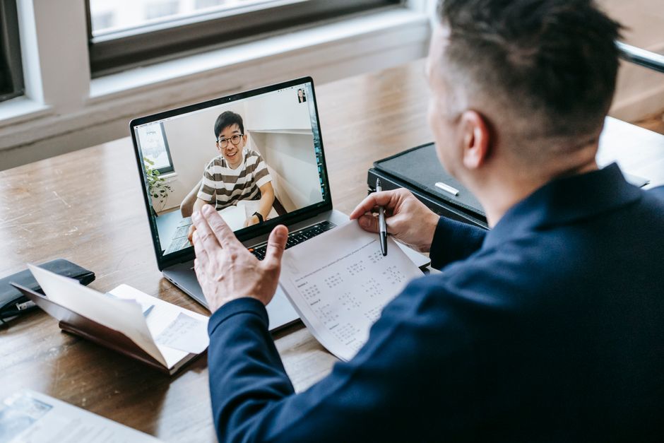 Um profissional tendo uma videoconferência em um laptop de um home office, engajando em comunicação online.